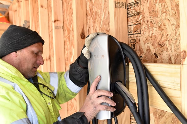 Licensed-electrician-installing-a-Tesla-connector-in-a-new-home-1