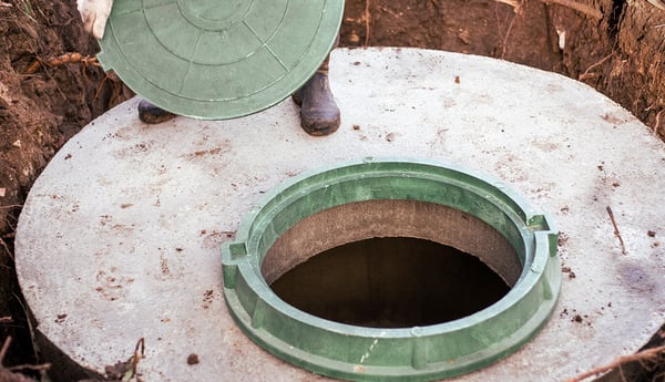 plumber-covers-the-sewer-well-with-a-manhole-cover-1