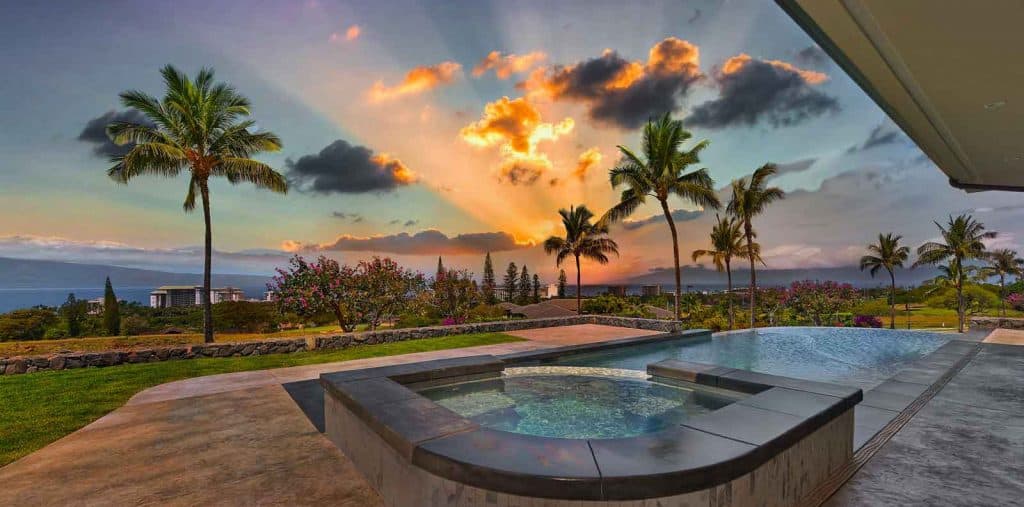 Sunset view from jacuzzi and pool of luxury Maui home by Crescent Homes Maui, a swimming pool contractor.