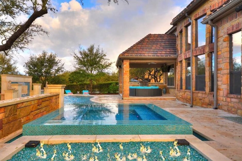Tiled pool and brick patio with natural gas feature built by a swimming pool contractor