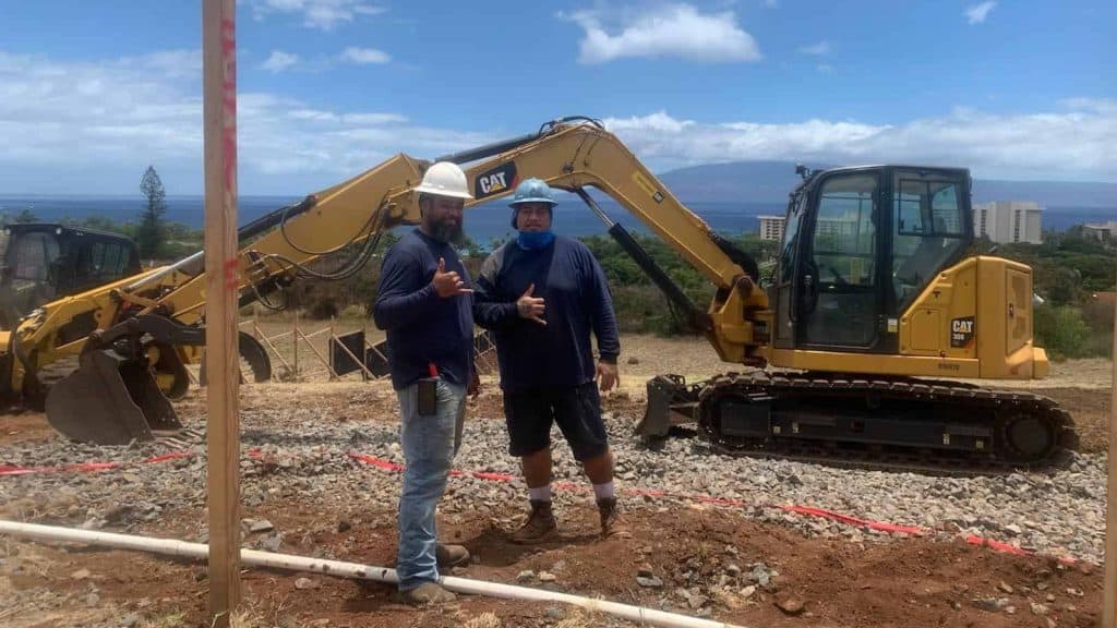 Excavator and employees at new home site on Maui