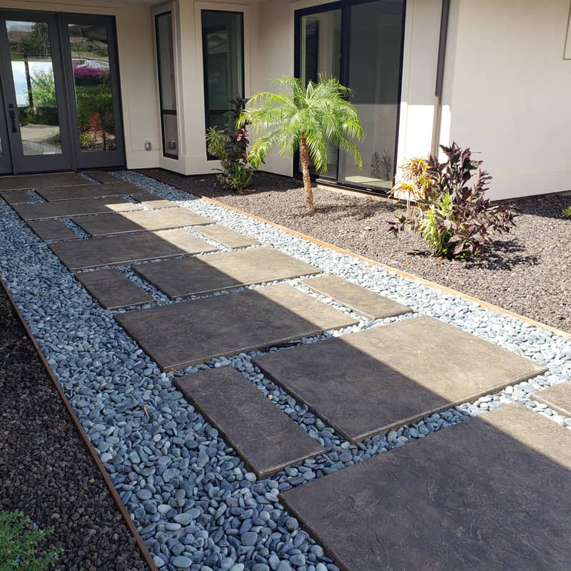 Image of a stamped concrete walkway surrounded by decorative stones