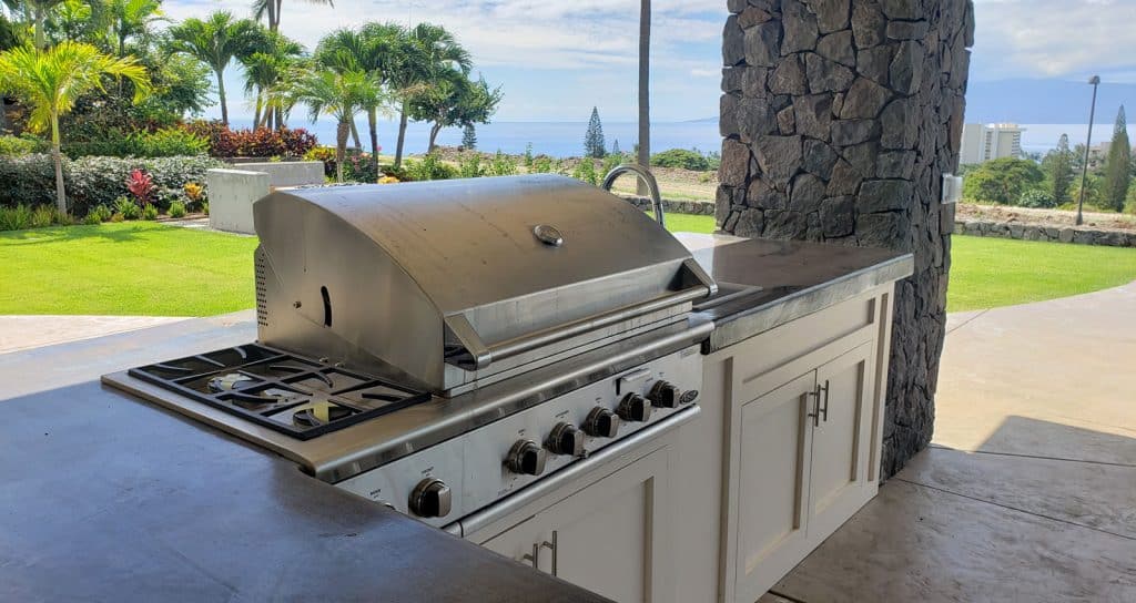 Outdoor kitchen grill and concrete counters with ocean view.