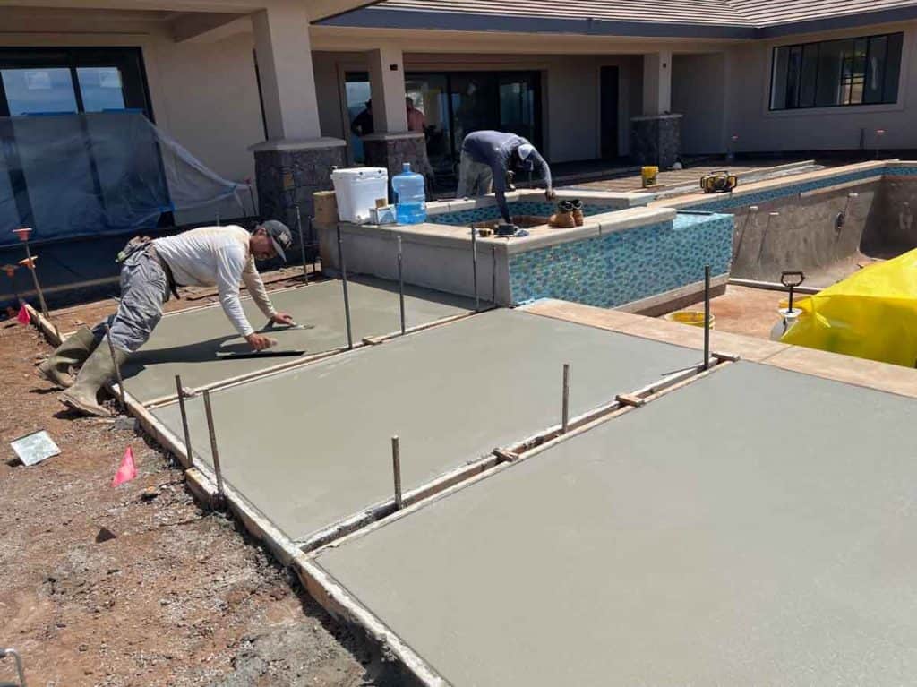 Crescent Homes Maui cement worker installing and smoothing a cement walkway for a dream home